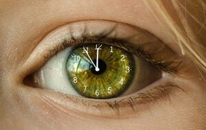 A green eye with the hands of a clock