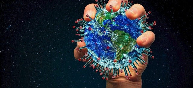 Hand holding the earth with virus spikes